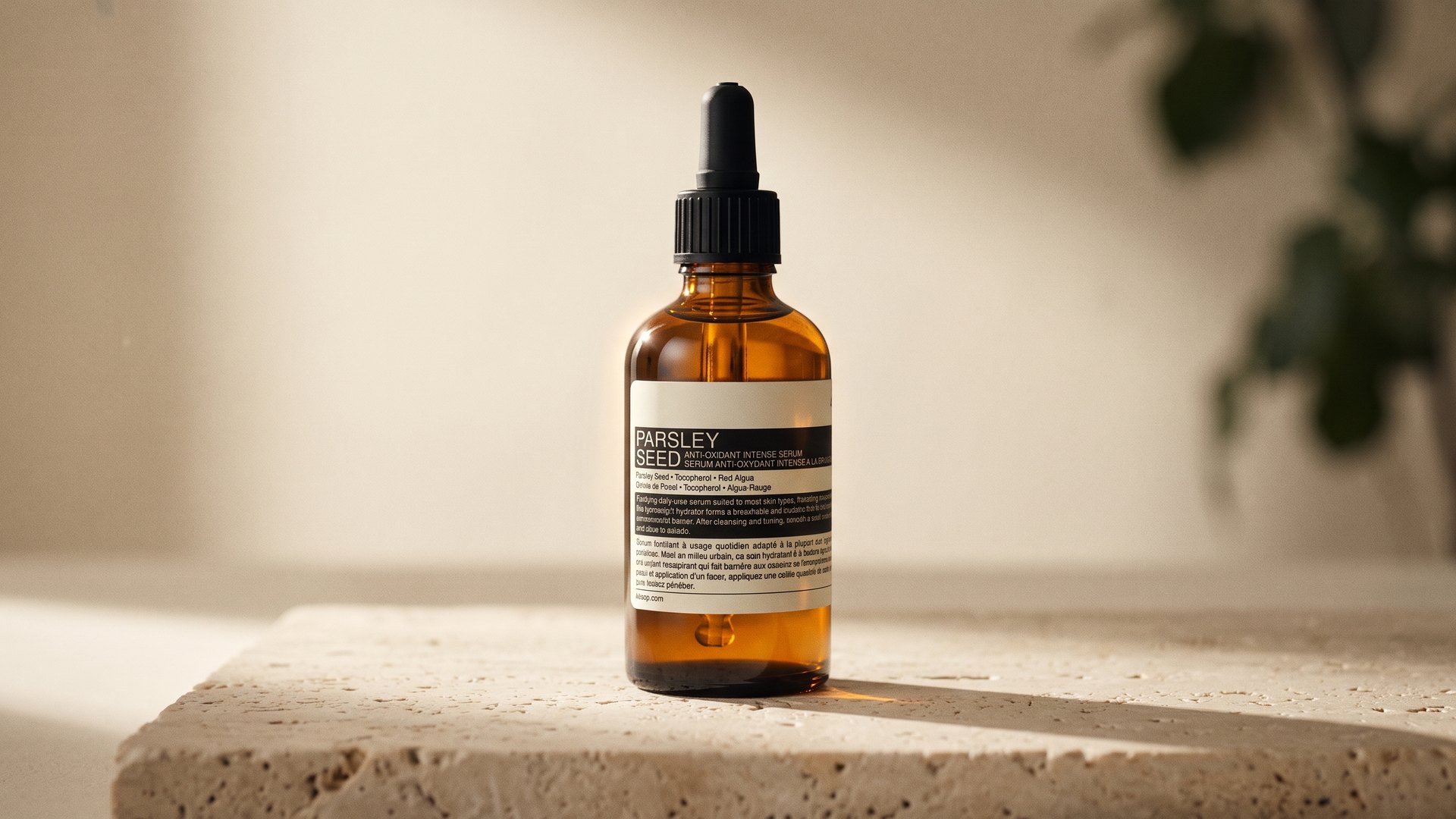 An amber Parsley Seed bottle on a travertine block in warm side light